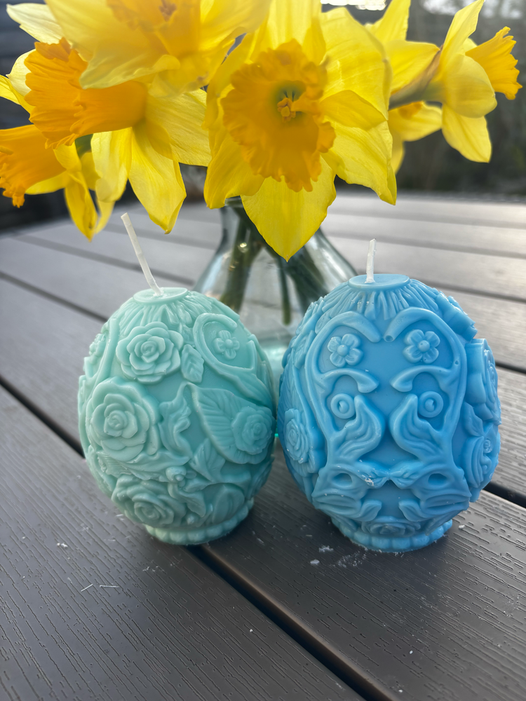 Easter themed eggs on a table next to some Daffodils